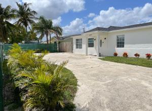 ein weißes Haus mit Palmen und einer Auffahrt in der Unterkunft Guest houses West Palm Beach 2BR or 1BR in West Palm Beach