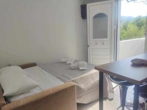 um quarto com uma cama, uma mesa e uma janela em Irini Apartment em Agios Nikolaos