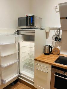 a kitchen with an open refrigerator with a microwave at Modernes City-Apartment mit Highspeed-WLAN & Top-Lage - Easy Stay Wuppertal in Wuppertal