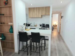 a kitchen with a white counter and black chairs at GRATA NERA in Rosario