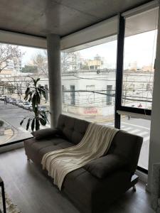 a couch in a living room with a large window at GRATA NERA in Rosario