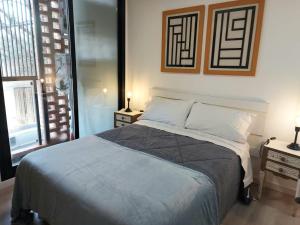 a bedroom with a bed with two night stands and a window at GRATA NERA in Rosario