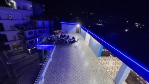 un groupe de personnes assises sur un balcon la nuit dans l'établissement MANAGYA COUNTRY VILLA, 