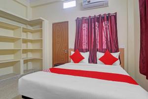 um quarto com uma cama grande e almofadas vermelhas em 80983G RBS Square Langer Houz em Haidar Sāhibgūda