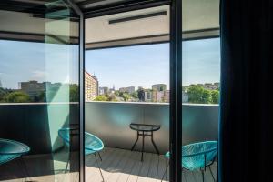 a balcony with a table and chairs and a view of the city at Hanza Tower Luxury in Szczecin