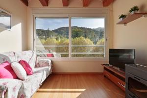 - un salon avec un canapé et une grande fenêtre dans l'établissement FANTÁSTICO PISO RIBES FRESER, à Ribes de Freser