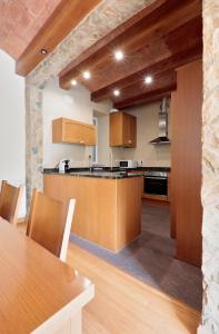 - une cuisine avec des placards en bois et une table dans une pièce dans l'établissement FANTÁSTICO PISO RIBES FRESER, à Ribes de Freser