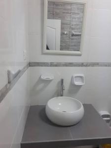 Baño blanco con lavabo y espejo en Casa de playa punta hermosa, en Punta Hermosa