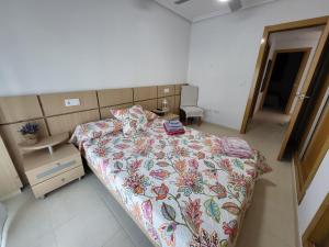 a bedroom with a bed with a floral comforter at La Casa de la Rivera in Culla