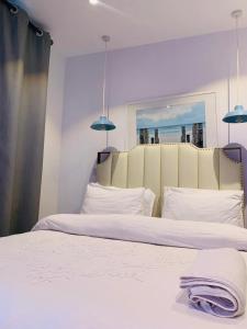 a bedroom with two beds with white sheets and blue lights at Executive Luxury Apartment Embassy Gardens in Accra