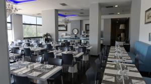 un restaurante con mesas blancas y sillas negras en Atlantic Sun & Love Apartment, en Portimão