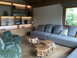 a living room with a couch and two chairs and tables at Chalet du Feug in Combloux