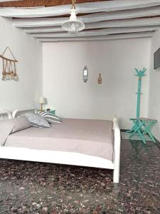 Cama blanca en habitación con techo en Στου Βάρδα, Χώρα, Σέριφος, en Serifos Chora