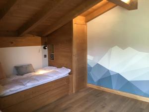 a bed in a wooden room with a window at Chalet du Feug in Combloux