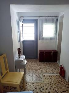 uma casa de banho com uma porta, uma mesa e uma cadeira em Στου Βάρδα, Χώρα, Σέριφος em Serifos Chora