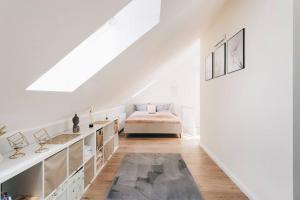 a white attic room with a bed and a staircase at NEU! 100 qm Apartment im Zentrum von Dresden in Dresden
