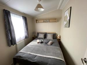 a bedroom with a bed with two towels on it at Comfy Cosy Caravan_Romney Sands in Littlestone-on-Sea