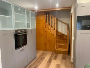 a kitchen with white cabinets and a wooden floor at Apartamento Dúplex Vistas al Valle de Incles Orenetes WiFi in Soldeu