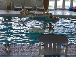 two people in the water in an indoor pool at Comfy Cosy Caravan_Romney Sands in Littlestone-on-Sea