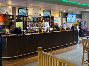 a bar in a pub with a person standing behind it at Comfy Cosy Caravan_Romney Sands in Littlestone-on-Sea