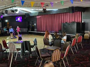 a group of people sitting in chairs in front of a stage at Comfy Cosy Caravan_Romney Sands in Littlestone-on-Sea