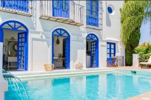 a villa with a swimming pool and blue windows at The Pearl - Marbella in Marbella