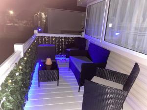 a balcony with chairs and lights on a building at Comfy Cosy Caravan_Romney Sands in Littlestone-on-Sea