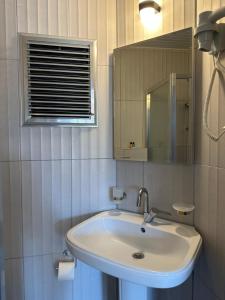 ein weißes Badezimmer mit einem Waschbecken und einem Spiegel in der Unterkunft NATURELLA APART HOTEL in Kemer