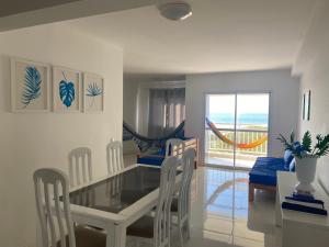 a dining room with a glass table and chairs at Apt agradabilíssimo vista mar in Lauro de Freitas