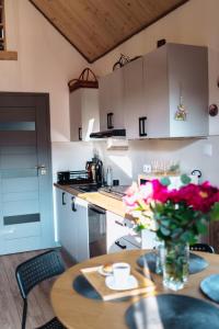 a kitchen with a table with a vase of flowers on it at Bieszczadzka Miejscówka in Lutowiska