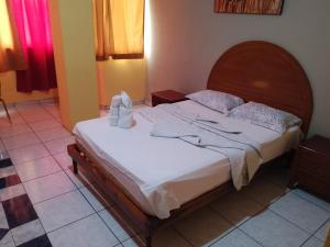 a bedroom with a bed with white sheets and shoes on it at Olmedo Plaza Hotel in Guayaquil +4 photos