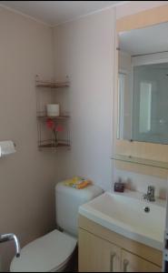 uma casa de banho com um WC, um lavatório e um espelho. em Magic Mobile Montourey, 3 chambres, 2 salles de bain, piscine disponible sur place em Fréjus