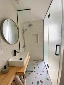 a bathroom with a sink and a mirror and a shower at La Puebla Rooms in Teror