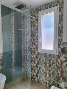 a bathroom with a shower with a window and a toilet at Villa Simo in Altavilla Milicia