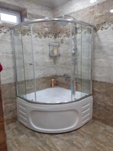 a shower with a white tub in a bathroom at Villa ELO in Kebele in Gabala