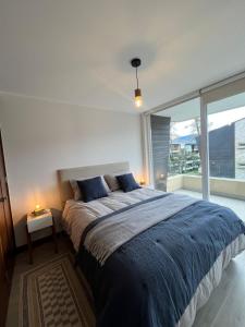 a bedroom with a large bed and a large window at Condominio Alta Vista Pucón in Pucón +14 photos