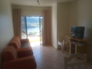 a living room with a couch and a television at Apartamento em Marcelino Ramos ao lado das Termas in Belém Velho