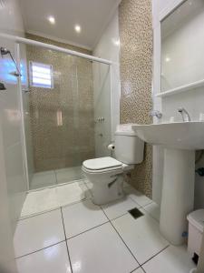 a bathroom with a toilet and a shower and a sink at Taroba Apart in Puerto Iguazú