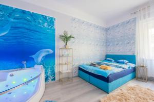 a bedroom with a dolphin mural and a bed and a bathtub at AquaFlat Gold in Budapest
