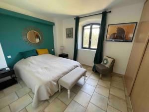 1 dormitorio con 1 cama grande y 1 silla en La Cath - Villa avec piscine - Gordes en Gordes