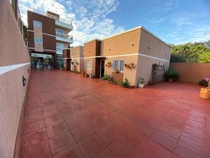 une cour vide d'un bâtiment avec une allée en briques dans l'établissement Taroba Apart, à Puerto Iguazú