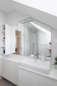 ein weißes Badezimmer mit einem Waschbecken und einem Spiegel in der Unterkunft Gravosa Stone House in Dubrovnik