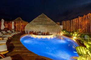 a swimming pool at a resort at night at Hotel Shibari - Restaurant & Cenote Club in Tulum