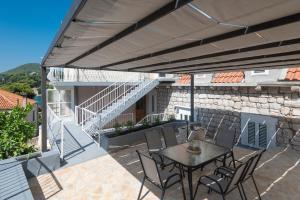 eine Terrasse mit einem Tisch und Stühlen sowie ein Gebäude in der Unterkunft Gravosa Stone House in Dubrovnik