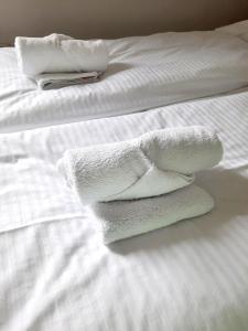 2 toallas blancas apiladas en una cama en Franko's Cozy Apartment with garage, en Zagreb