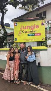 un grupo de personas de pie delante de un cartel en Jungle by sturmfrei Vagator en Vagator