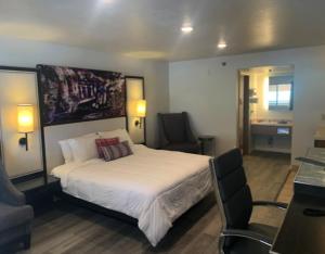 een slaapkamer met een bed en een stoel erin bij GO2 Inn & Suites by Relianse in El Paso