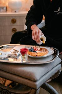 une personne versant du sirop sur une assiette alimentaire dans l'établissement The Ritz-Carlton, New Orleans, à La Nouvelle-Orléans