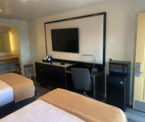 een hotelkamer met een bed, een bureau en een televisie bij GO2 Inn & Suites by Relianse in El Paso