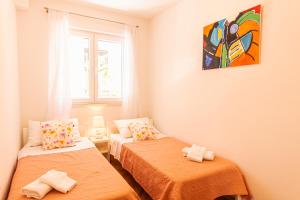Habitación con 2 camas y una pintura en la pared. en Stylish apt Marta, private parking,BBQ in Stobreč en Stobreč
